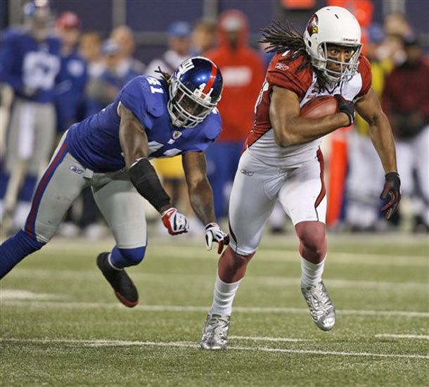 Larry Fitzgerald runs away from the  Giants' C.C. Brown 